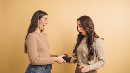 Surprised women exchanging a gift with excitementの写真素材
