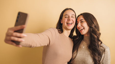 Two friends smiling while taking a selfie togetherの写真素材