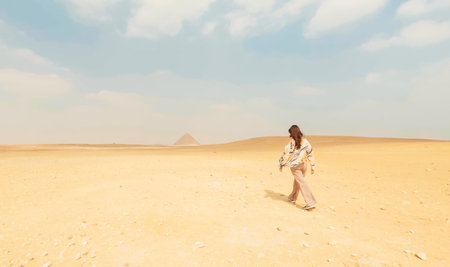 Tourist walking in the desert towards the pyramids of gizaの写真素材