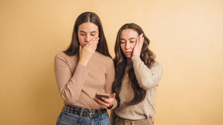 Two women reacting to surprising news on smartphoneの写真素材