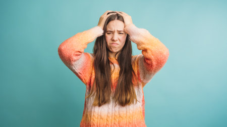 Woman expressing frustration with hands on headの写真素材