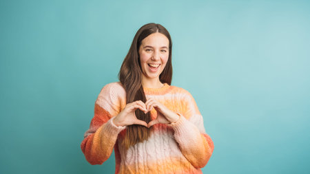 Woman expressing joy with heart hand gestureの写真素材