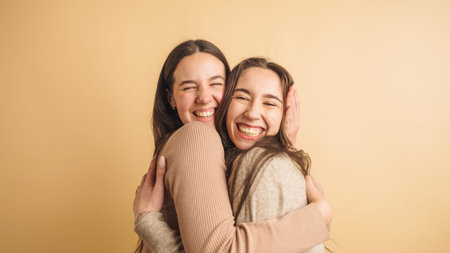 Two joyful friends embracing with laughterの写真素材