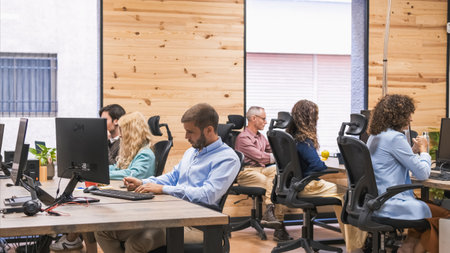Focused businesspeople working at computer desks in creative officeの写真素材