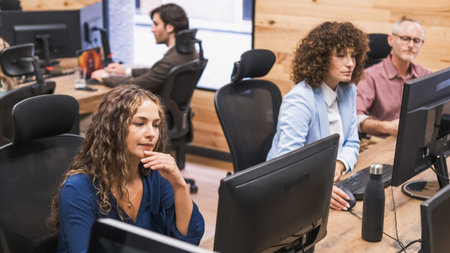 Focused businesswomen using computers at desk in office