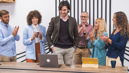 Happy team applauding for young businessman after presentation in conference room