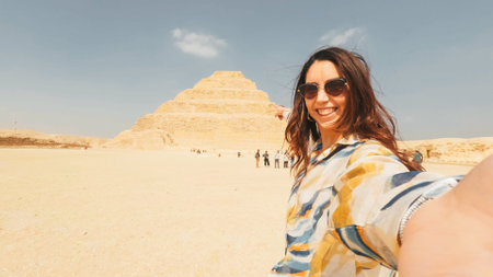 Tourist taking selfie with the step pyramid of djoser in saqqara, egyptの写真素材