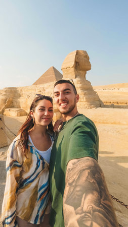 Tourists taking selfie with great sphinx of giza and pyramid of khafre in background