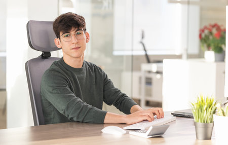 Young businessman typing on keyboard in modern office