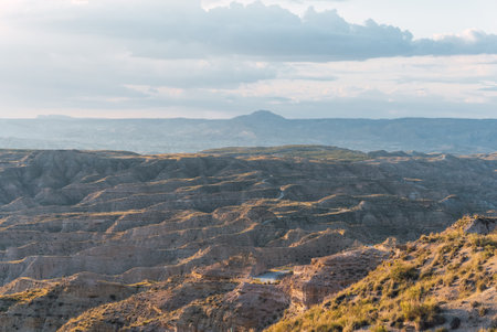 Desert landscape showing erosion in gorafe, spain, at sunsetの写真素材