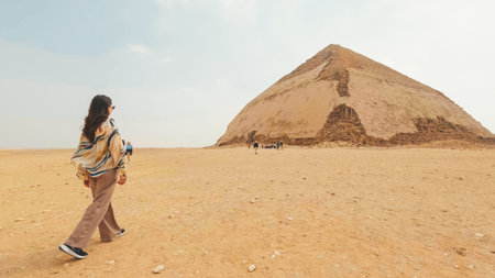 Tourist walking towards the bent pyramid in the desert of dahshur, egypt
