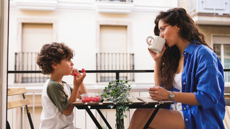 Mother and son enjoying breakfast on balcony: sharing a peaceful momentの写真素材