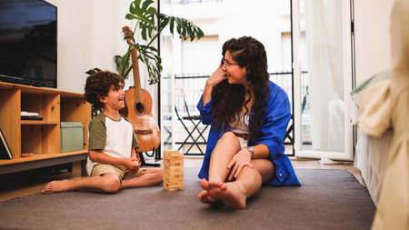 Mother and son having fun playing with wooden blocks at homeの写真素材