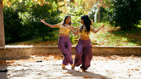 Two indian women performing traditional dance in parkの写真素材