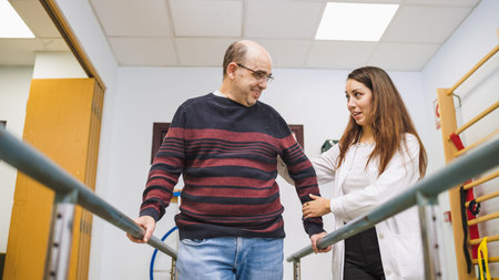 Physiotherapist assisting patient during walking rehabilitation exercise