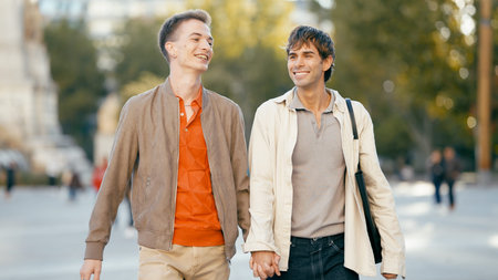 Smiling gay couple walking together holding hands