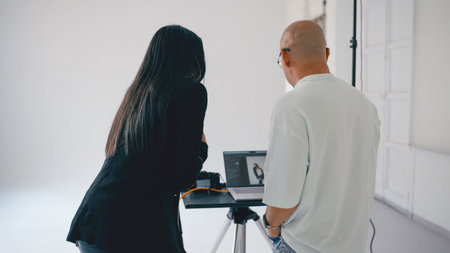 Photographers reviewing photos on laptop after photoshoot session