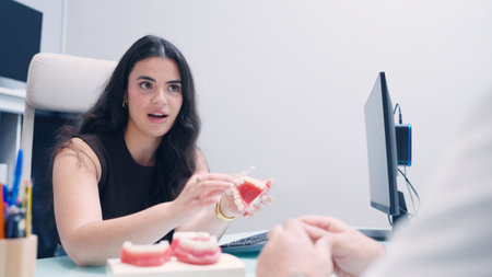 Female dentist explaining dental care to patient