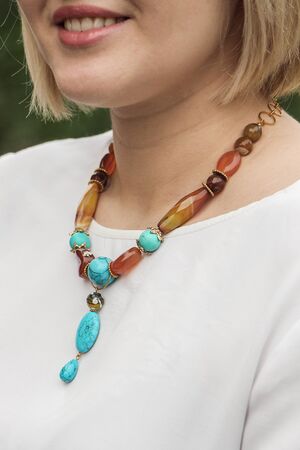 Close up view of a girl with long hair wearing a gray sweater and a necklaceの写真素材