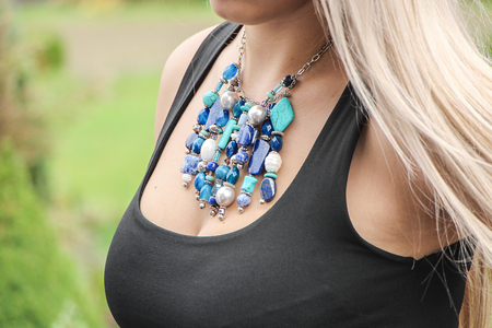 Close up view of a girl with long hair wearing a gray sweater and a necklaceの写真素材
