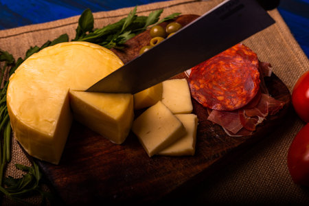 Cheese with serrano ham, olives on a table for a party with friends or as an aperitifの写真素材