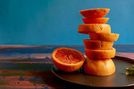 Grapefruits on blue background and decorated plate, to make juices or to enjoy in an afternoon at homeの写真素材