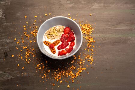 Dish with yogurt, strawberries, granola, nuts, ideal for an energy-packed vegetarian dietの写真素材