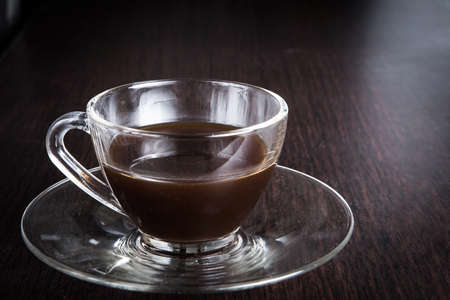 a cup of coffee on the wood floors backgroundの写真素材