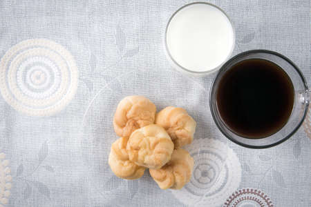 a plate of choux cream with a cup of coffee on the tableの写真素材