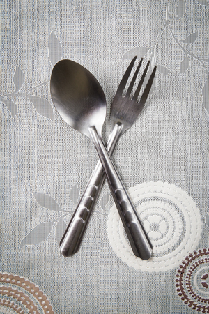silver fork and spoon cross on the tableの写真素材