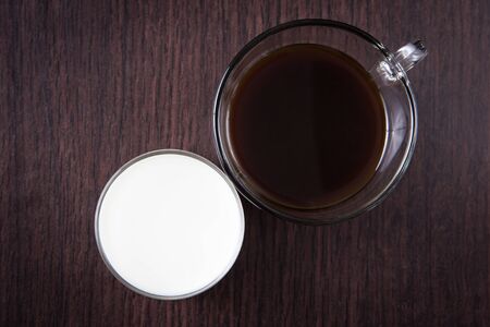 a cup of coffee and a cup of milk on the wood tableの写真素材