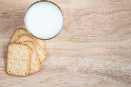 Salty crackers in square shape with a cup of milkの写真素材