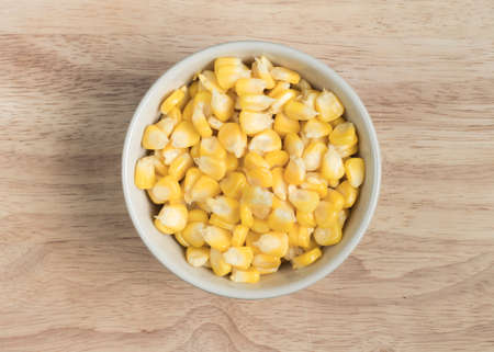 a bowl of corn seed on the wood blockの写真素材