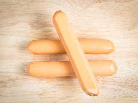 two sausage arrange as unequal expression on the wood blockの写真素材