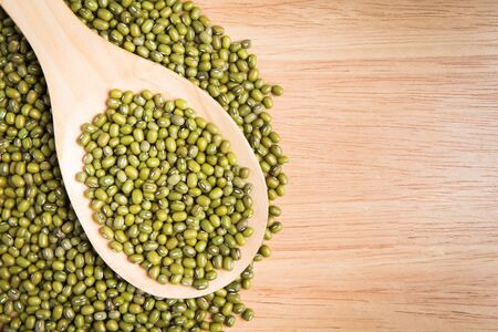 scoop of green beans seed on a pile of green bean seedの写真素材