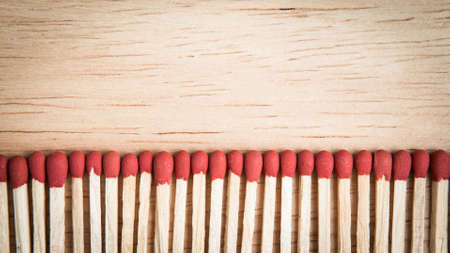 pile of match arrange in a row on a wood backgroundの写真素材