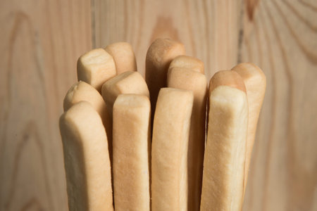 Pack of  bread stick in front of a blurry wooden background.Selective focus.