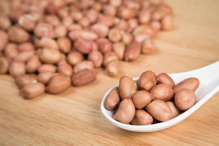 spoon of peanut in front of blurry pile of peanut.Selective focus.の写真素材
