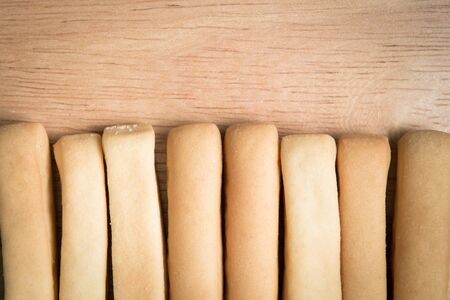 row of  bread stick arrange on a wooden background.の写真素材