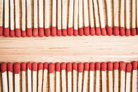 pile of match arrange in a row on a wood background.の写真素材