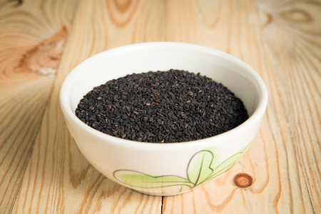 bowl of black sesame on a wooden backgroundの写真素材