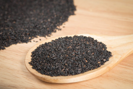 scoop of black sesame in front of a blurry pile of black sesame.Selective focus.の写真素材