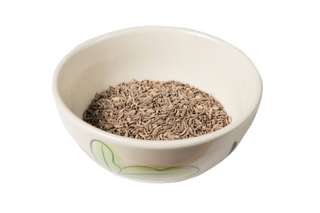 Isolated bowl of dried cumin seed on the white backgroundの写真素材