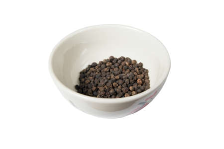 Isolated bowl of black dried pepper on a white backgroundの写真素材