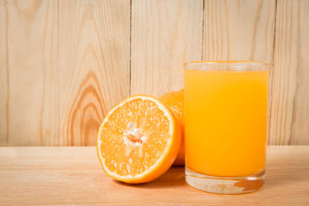 orange fruit and a cup of orange juice on a wooden blockの写真素材