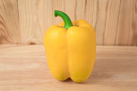 yellow sweet pepper on a wooden blockの写真素材