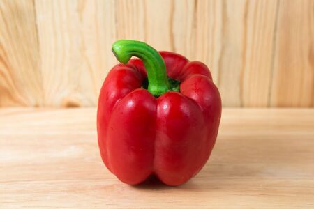 red sweet pepper on a wooden blockの写真素材