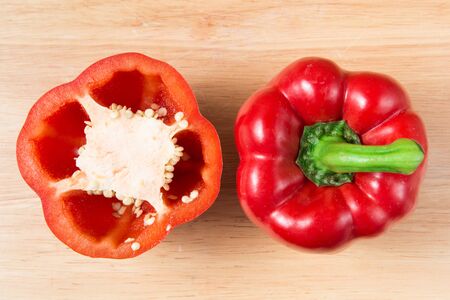 red sweet pepper and a half on a wooden blockの写真素材