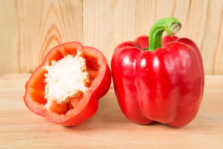 red sweet pepper and a half on a wooden blockの写真素材