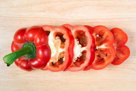 sliced red sweet pepper on a wooden blockの写真素材